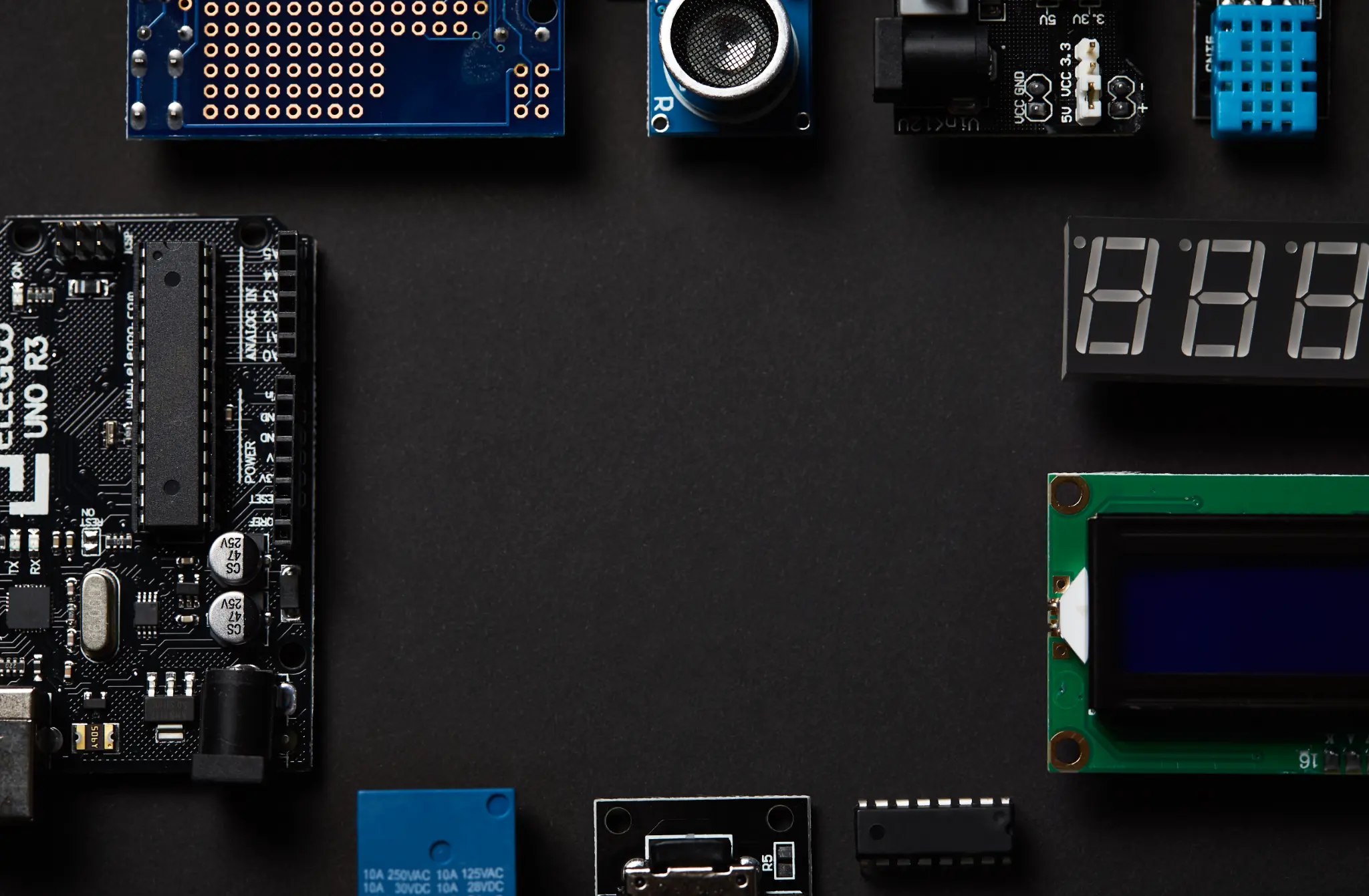 Electronics and technology components laid out on dark background for DIY setup