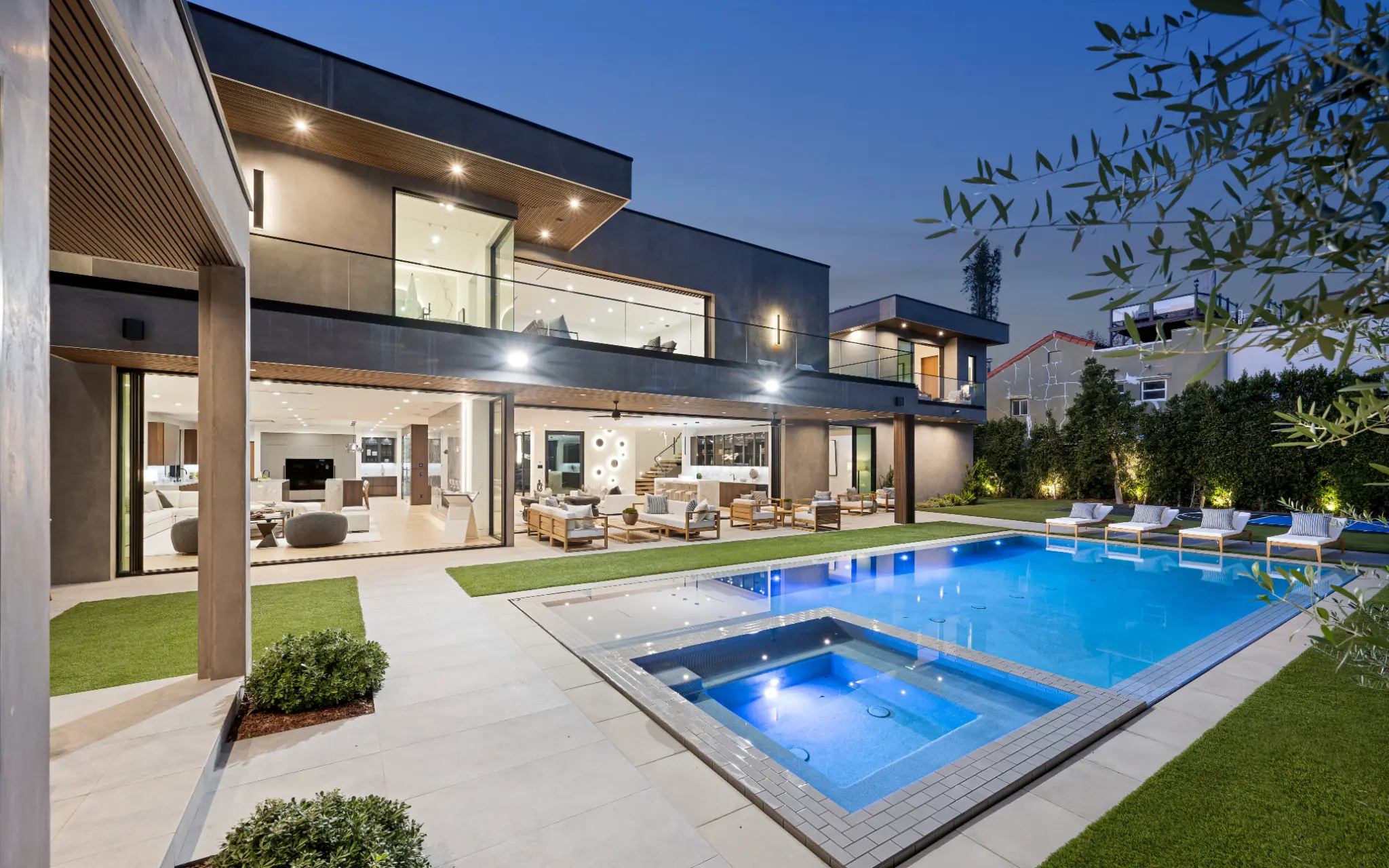 Modern luxury home with illuminated pool at night